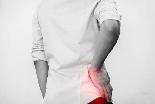 man holding his hip because of hip pain